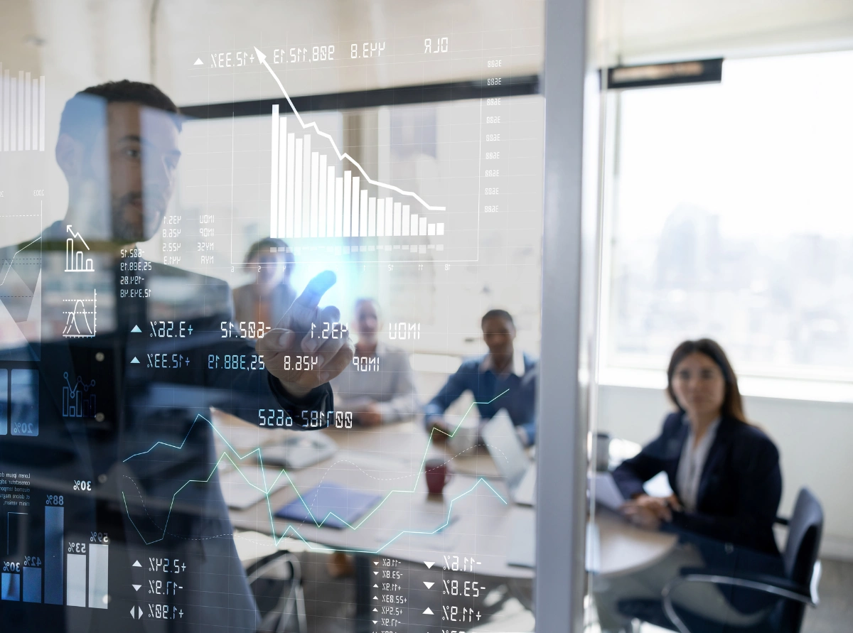 Business professional standing in front of light board presenting data.